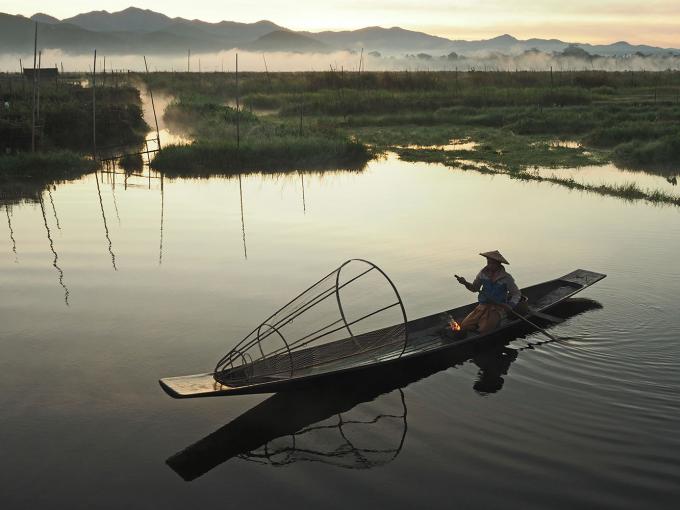 Une embarcation cambodgienne sur les eaux du Mékong, pêche illégale, disparition du dauphin de l'Irrawaddy