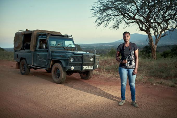 Een vrijwilliger van een anti-stroperij patrouille in een jeep in de Afrikaanse savanne bij het vallen van de avond