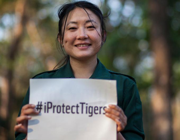 Femme tenant une pancarte "#Iprotecttigers" travaillant pour la protection des tigres